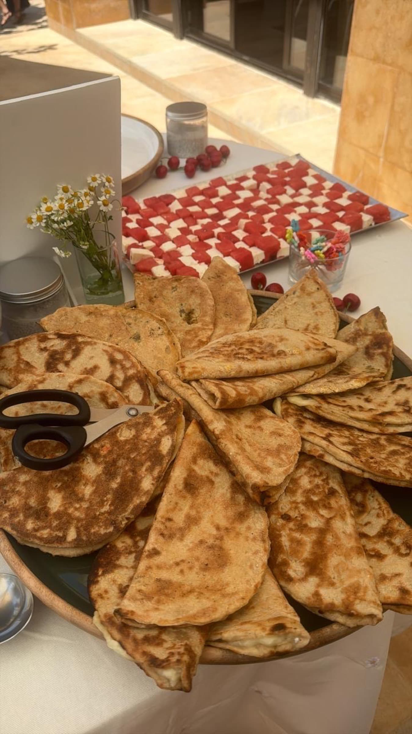 A wide platter of man'ouché beside the watermelon and feta checkerboard