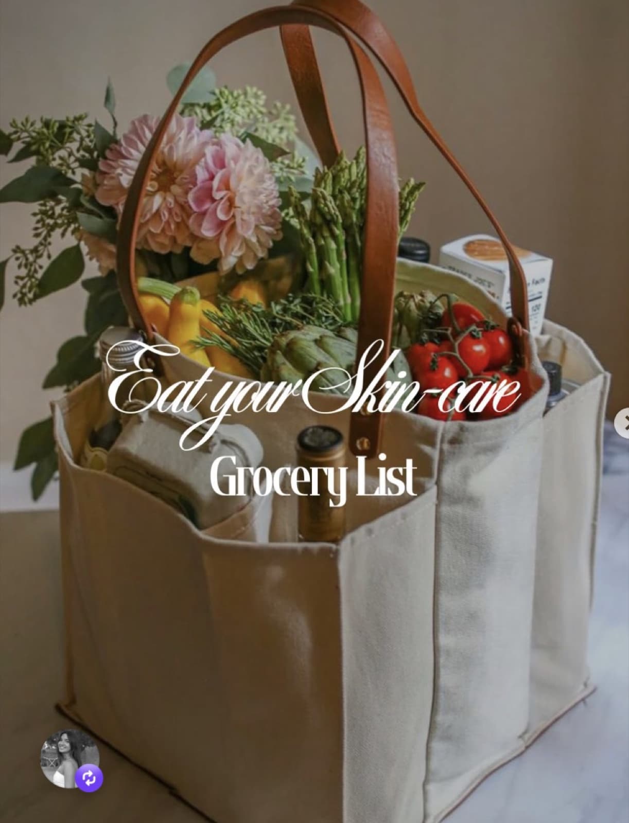 A canvas market tote packed with tomatoes, asparagus, artichokes and pink dahlias