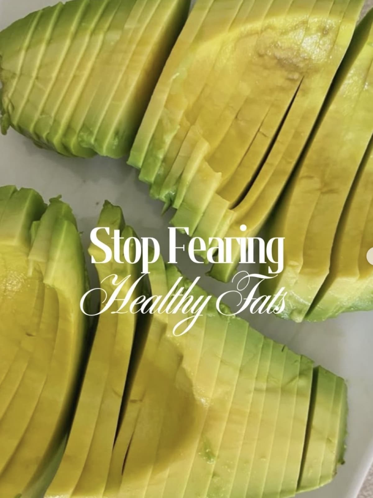 Close-up of a thinly sliced avocado, fanned out across a white plate